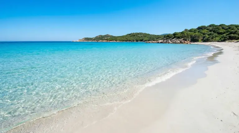 Spiaggia italiana con sabbia bianca e mare cristallino in una giornata soleggiata