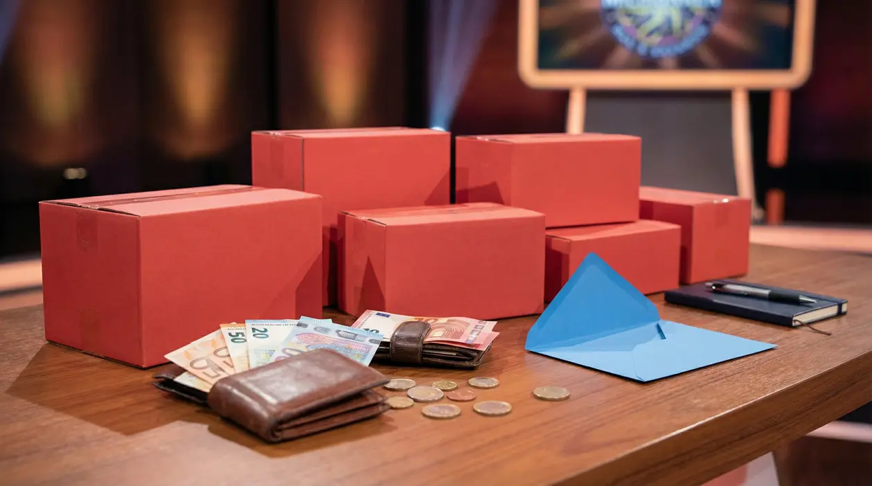 Scatole rosse, portafogli con denaro e monete su un tavolo di un game show